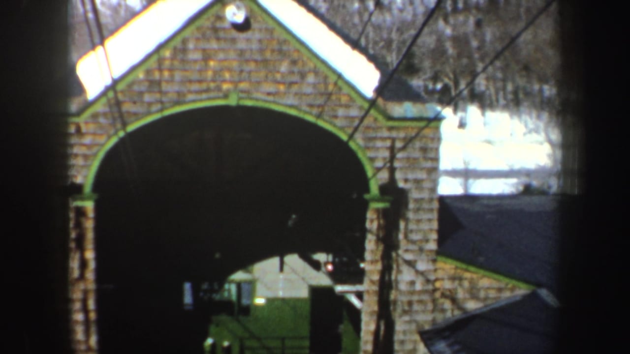 Large brick arch with green-painted edging and a dark opening below.