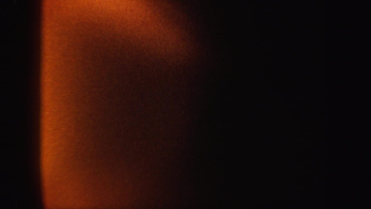 1962 8mm New York home-movie frame with a soft orange vertical band emerging from a black background.