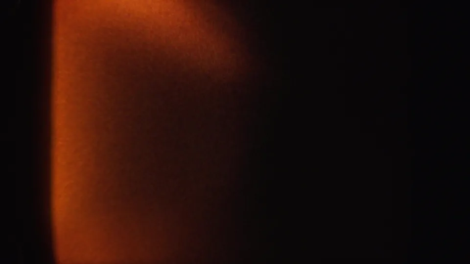 1962 8mm New York home-movie frame with a soft orange vertical band emerging from a black background.