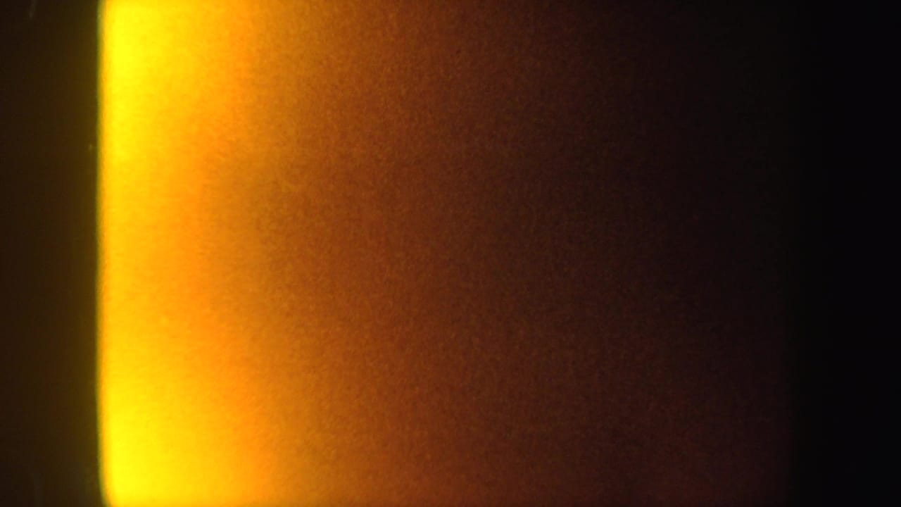 1962 8mm New York frame with a strong yellow-orange vertical glow and dark surrounding exposure.