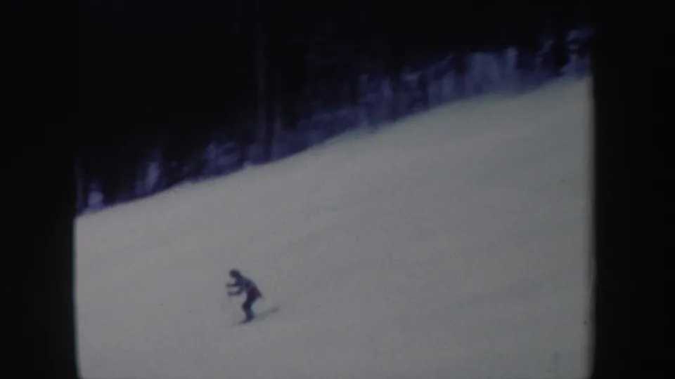 A distant skier in dark clothing moves across a snowy New York slope in this 1962 home-movie frame.