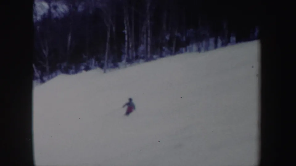 1962 New York 8mm frame with the lone skier farther downhill on a broad snow-covered slope.