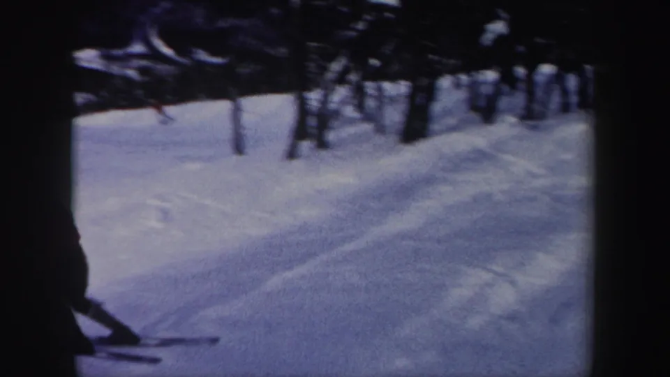 Snow-covered New York ski slope in 1962, with dark trees and part of a skier appearing at the left edge.
