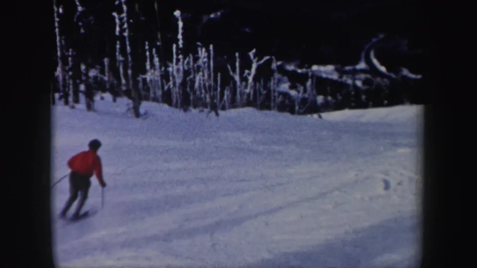A skier in a red jacket practices a turn on a snowy New York slope in this 1962 8mm home-movie frame.