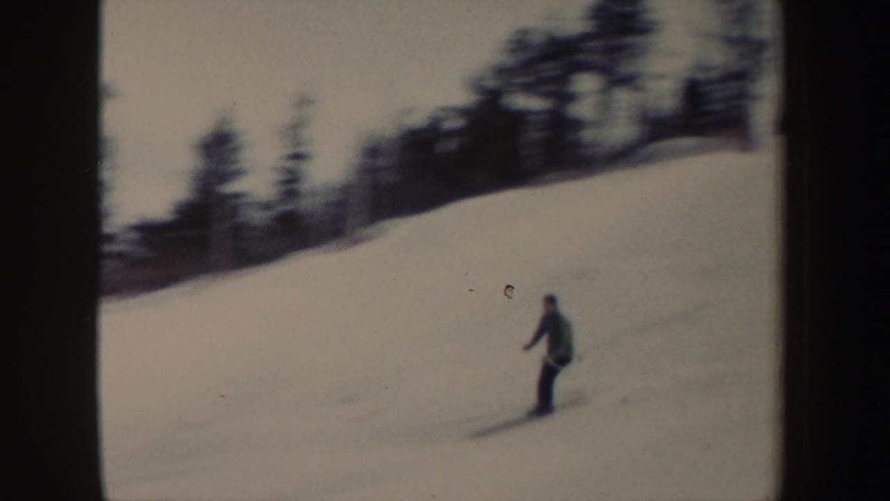The handheld 8mm view follows a skier descending a broad snowy slope in 1962 New York.