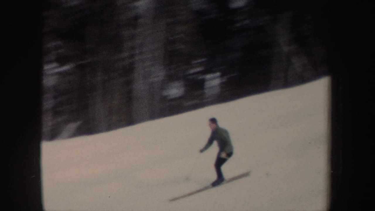 A closer frame shows the lone skier leaning into a downhill run, with wooded terrain behind him.