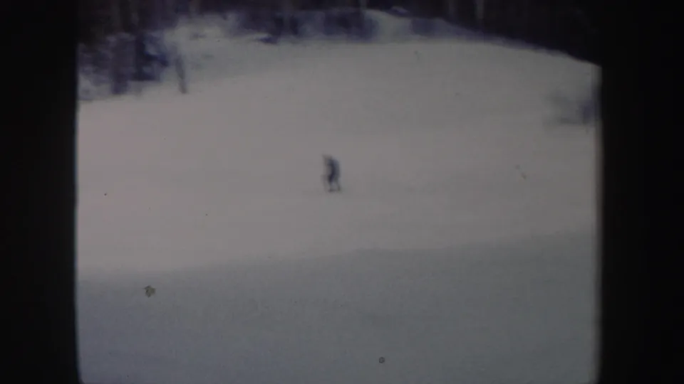 A distant skier appears on a broad snowy slope in archival 8mm footage from New York, 1962.