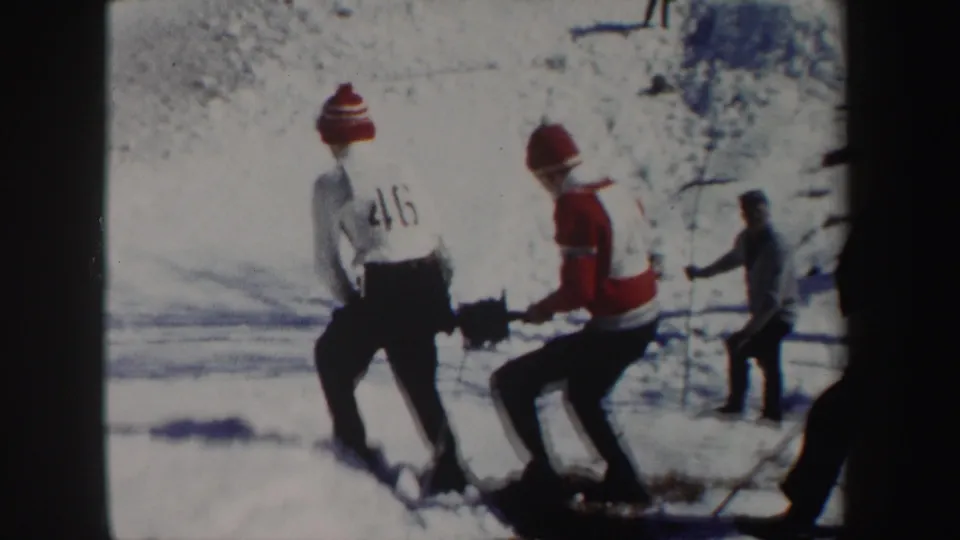 1962 New York 8mm frame of a young man marked 46 and another in red winter clothing working on a snowy area.