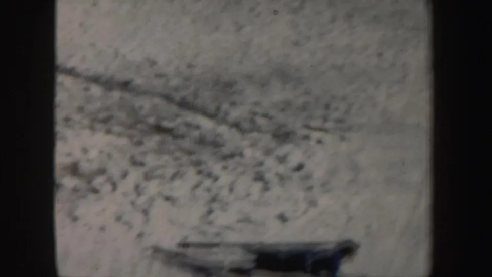 Blurred 1962 New York ski footage with a skier moving quickly across snow, partially softened by motion and exposure.