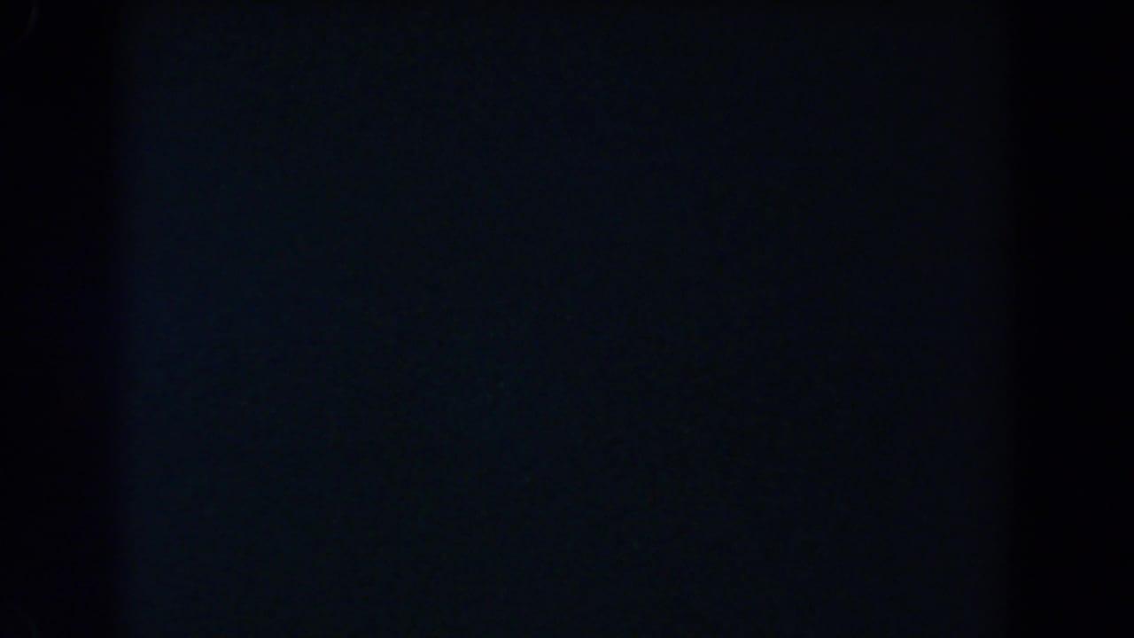 Underexposed 8mm frame with a central vertical dark band and faint blue-black areas, based on the 1962 Glendale clip metadata.