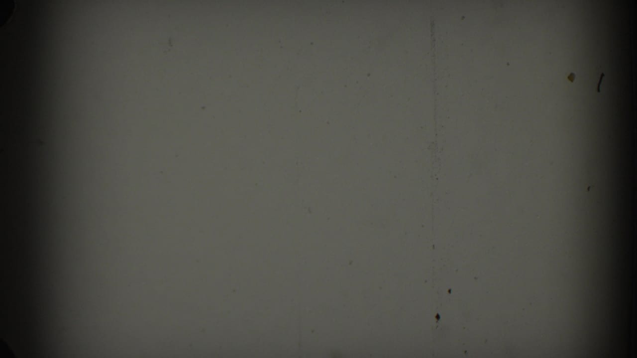 1962 Glendale 8mm frame showing a mostly blank gray field with film grain, specks, and dark gate shadows.