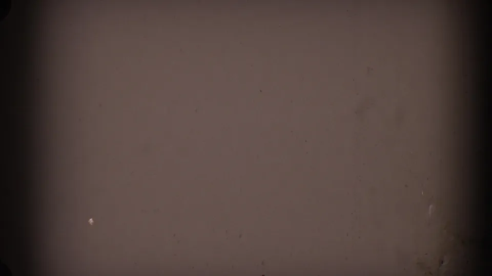 1962 Glendale 8mm frame with a dark vertical band dividing a brown-tinted, grainy surface with dust and a small light speck.