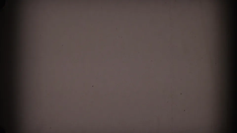1962 Glendale 8mm frame showing a gray-brown exposed film surface with dark side bands, visible grain, dust, and scratches.