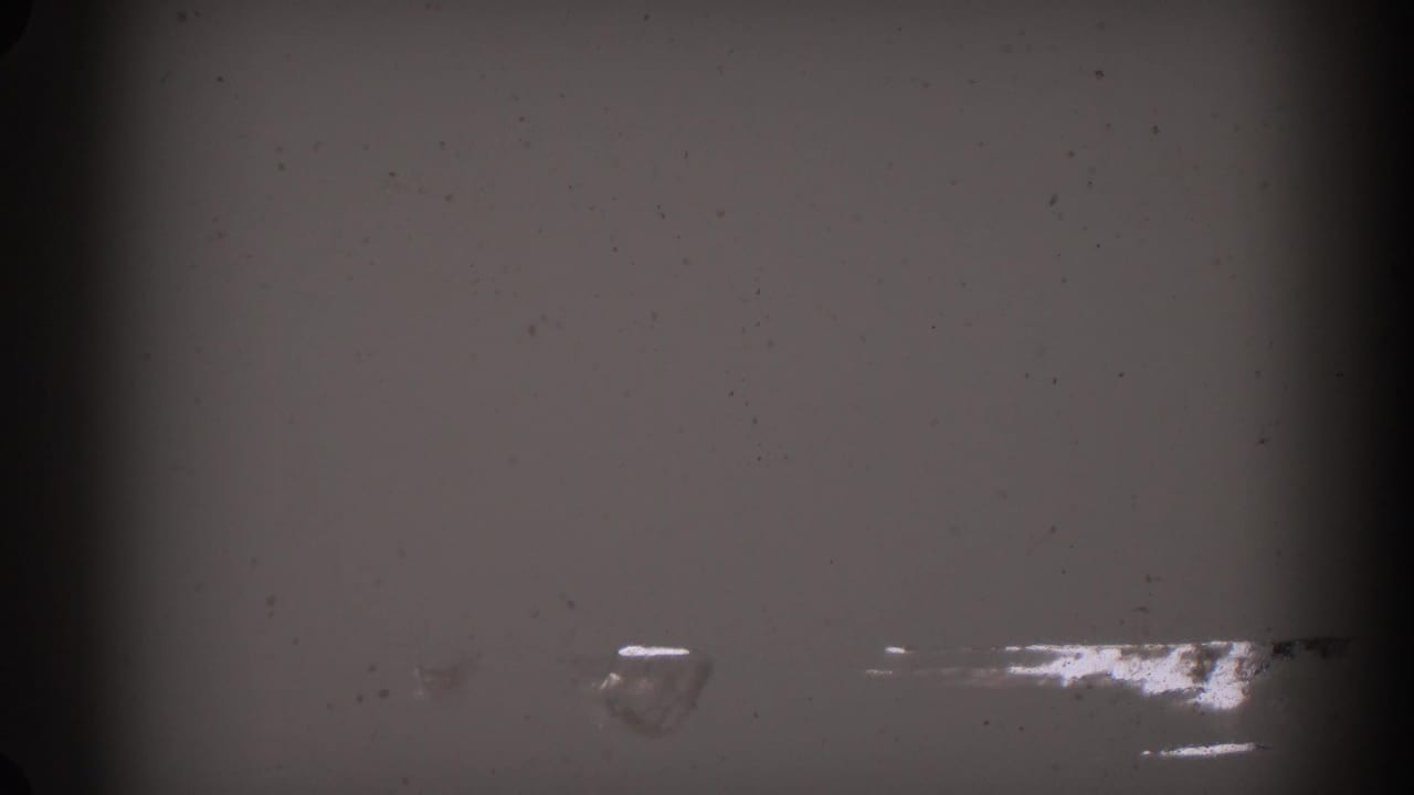 1962 Glendale 8mm frame showing mostly blank, damaged-looking film with dust, grain, and dark vertical gate edges.