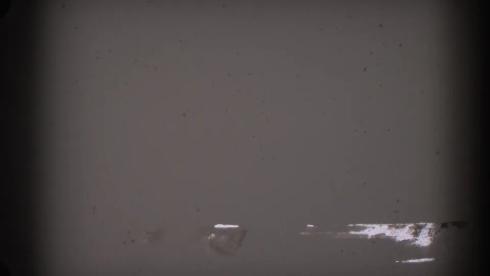1962 Glendale 8mm frame showing mostly blank, damaged-looking film with dust, grain, and dark vertical gate edges.