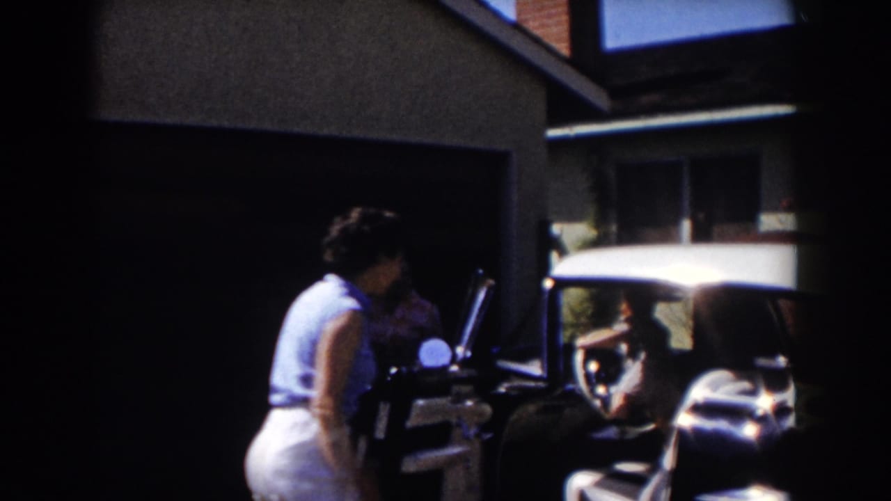 Woman near the car door as another person is partly visible in the shaded garage area.