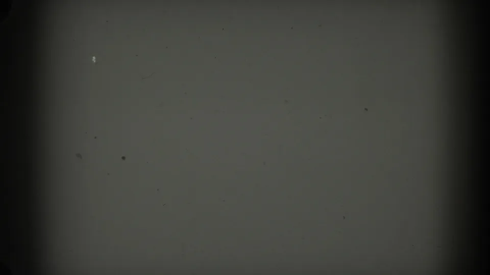 Low-exposure 1962 Glendale 8mm frame showing gray film texture, a horizontal divider, dark side banding, dust, and grain.
