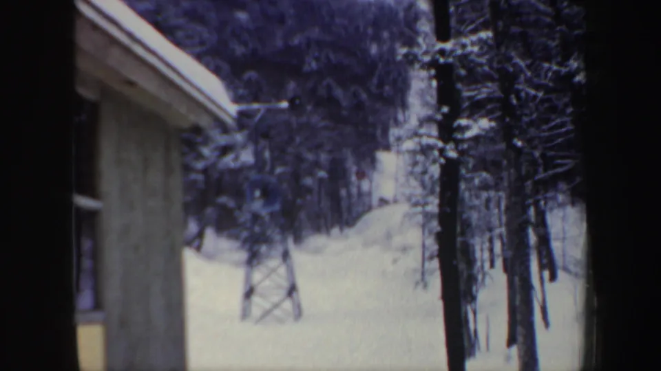The final frame shows the snowy New Hampshire ski-area view, with trees and lift tower seen past a building edge.