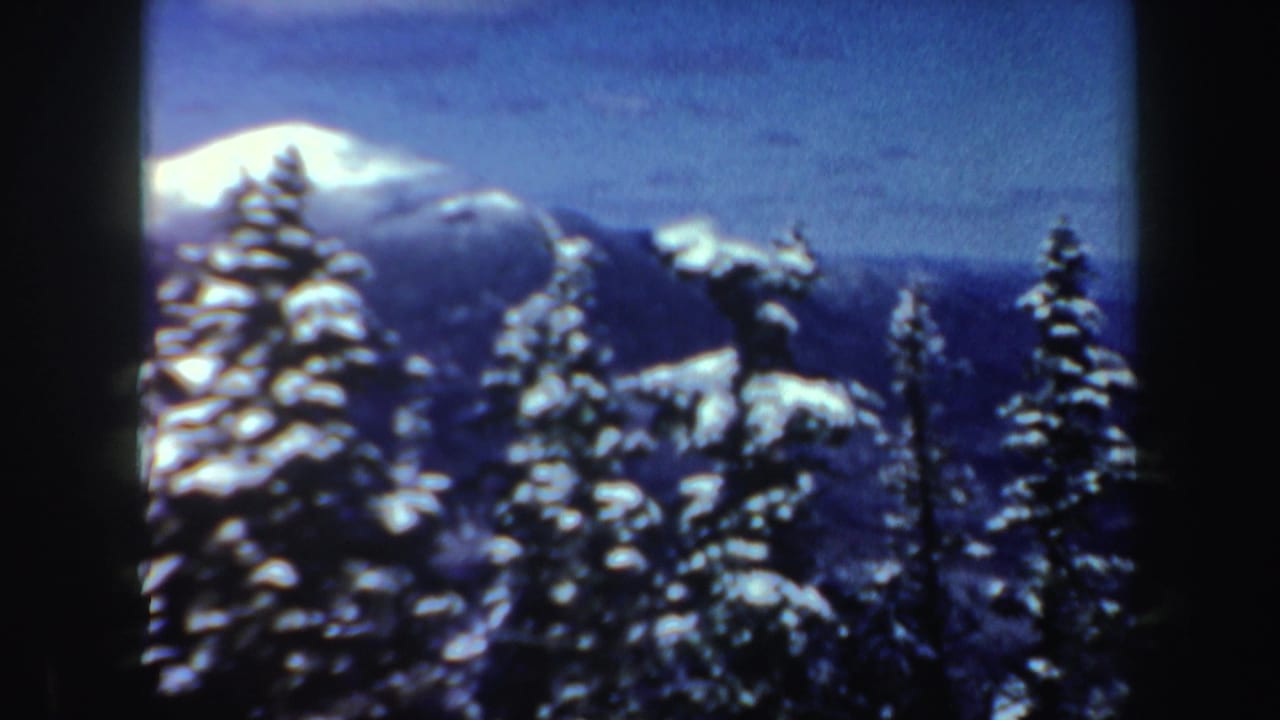 End frame shows a snowy New Hampshire mountain landscape with dark pines and pale ridges in soft 8mm color.