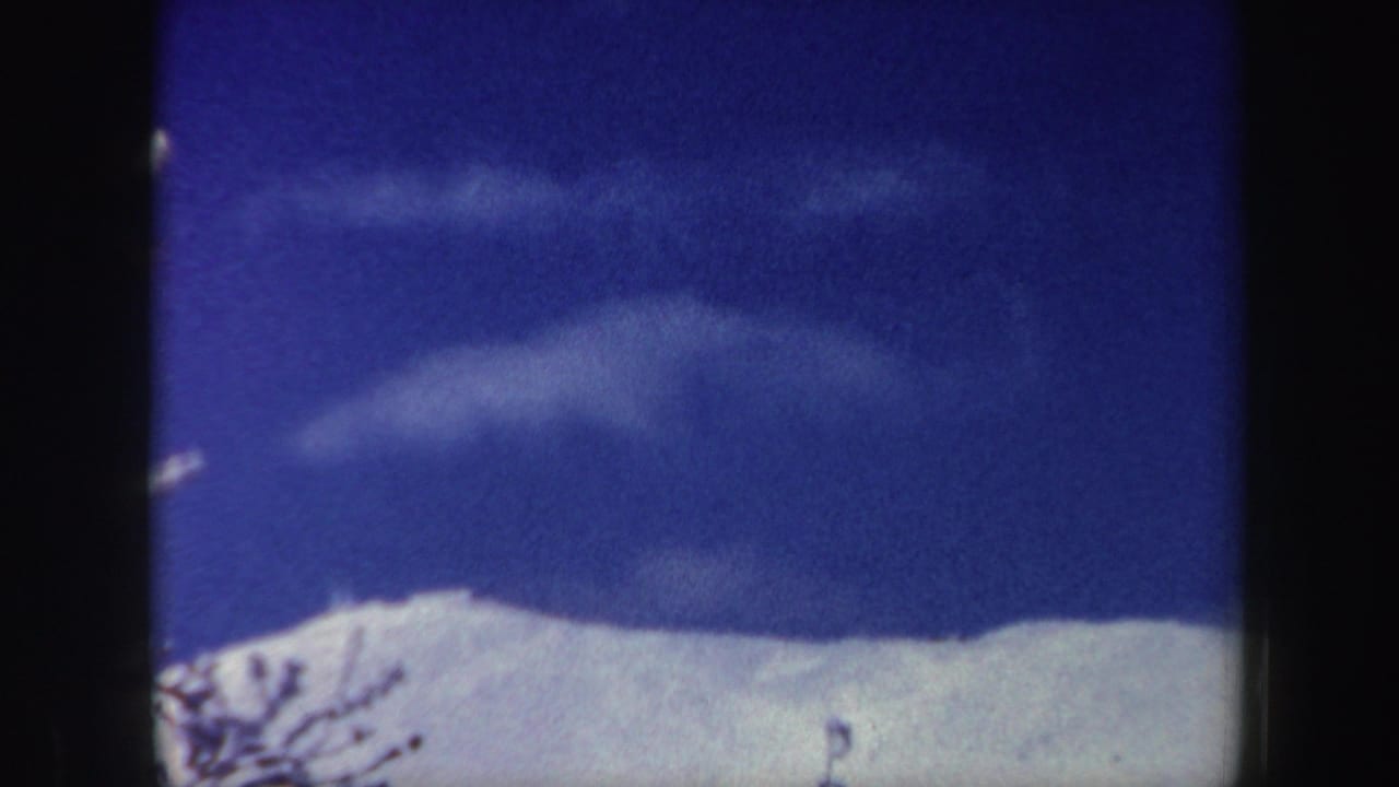 A similar 1962 New Hampshire mountain view, with bright snow, wispy clouds, and visible film gate edges.