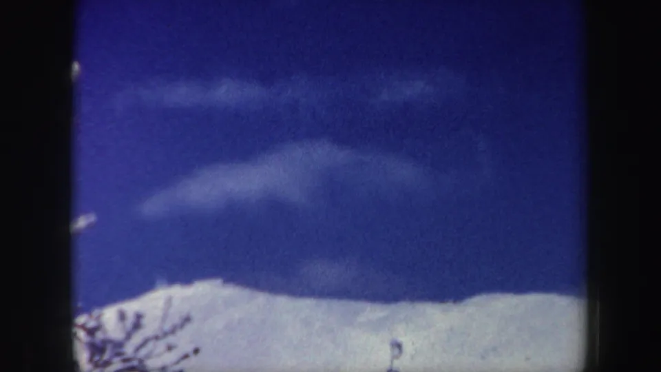 A similar 1962 New Hampshire mountain view, with bright snow, wispy clouds, and visible film gate edges.