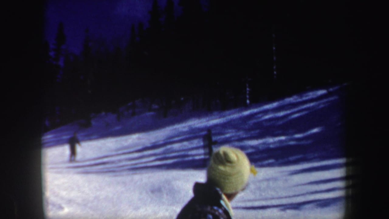A light-hatted foreground figure faces distant skiers on a snowy New Hampshire slope, with dark evergreens along the upper hill.