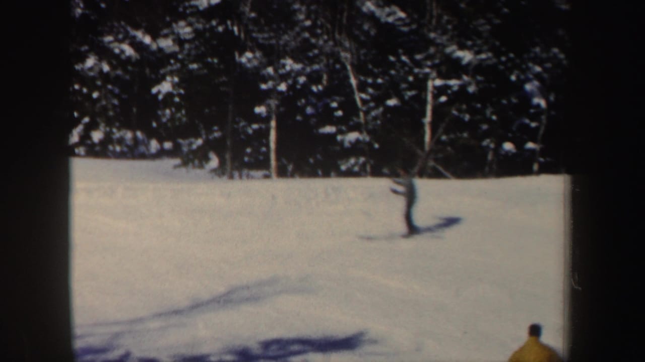 1962 New Hampshire ski footage frame with a partly visible skier entering the lower right of a sunlit snowfield.
