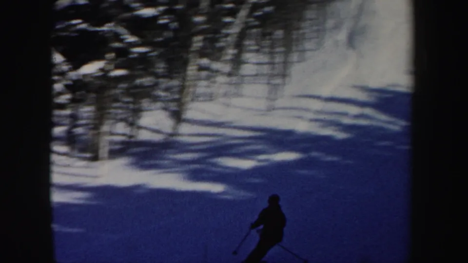 A lone skier crosses a snowy New Hampshire slope in this 1962 home-movie frame.