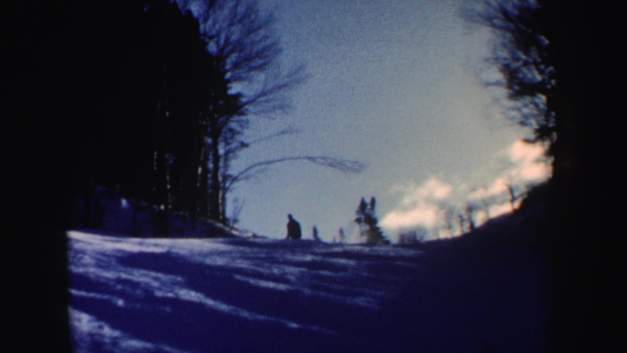 The final frame shows a distant person on a snow-covered New Hampshire slope, bordered by leafless trees in blue 8mm color.