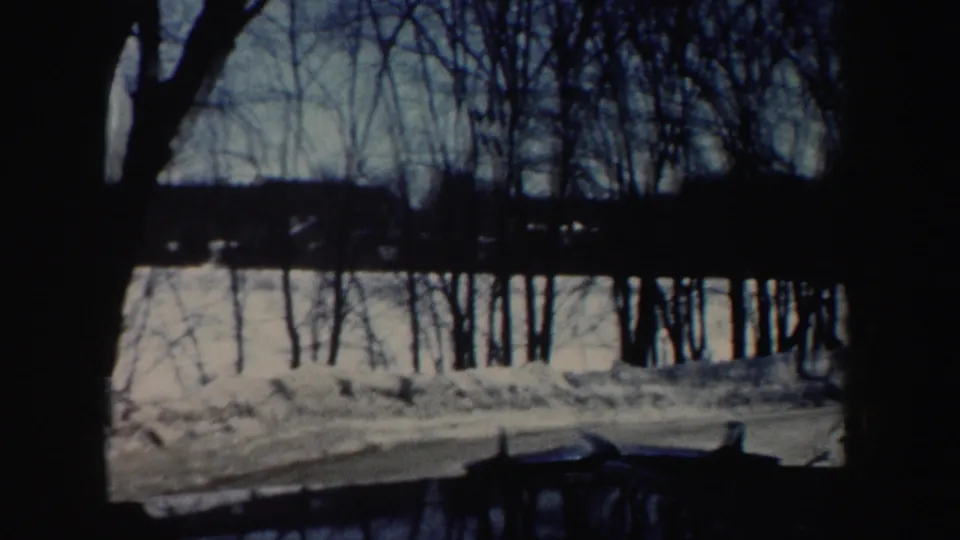 A snow-covered roadside and leafless trees appear in the same New Hampshire winter home-movie sequence.