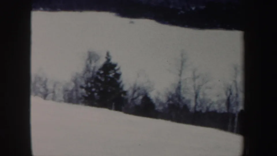 1962 New Hampshire 8mm frame showing the snowy hillside after the skier has moved out of view.