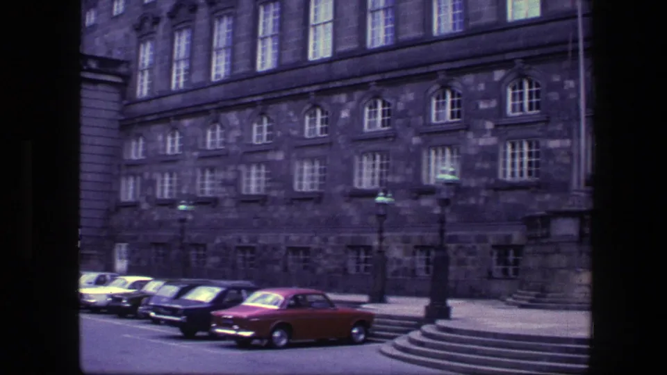 1975 Copenhagen street view of an ornate stone building, parked classic cars, and a broad staircase crossing the lower frame.