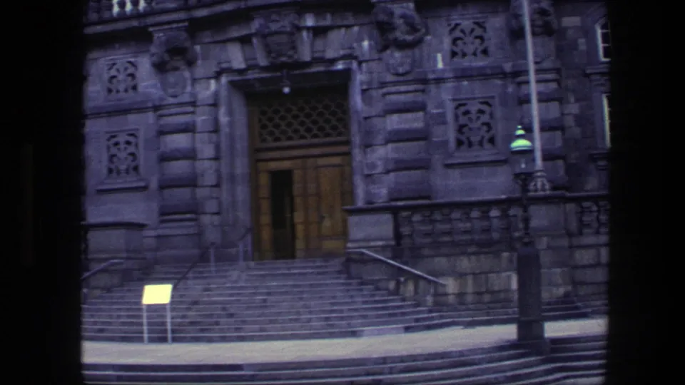 1975 Copenhagen exterior holding on the ornate doorway, broad stone staircase, metal railings, signboard, and nearby lamppost.