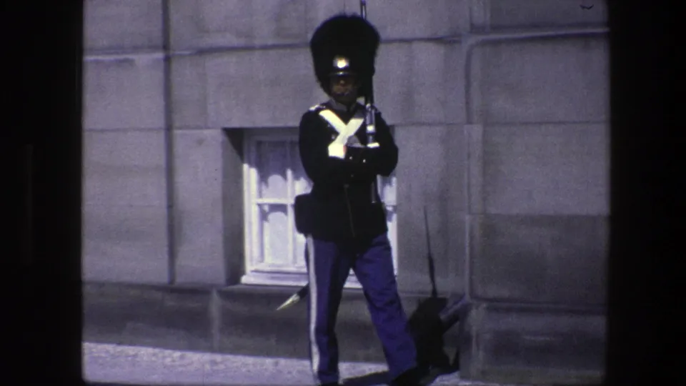 The 1975 Copenhagen footage shows a ceremonial soldier facing forward outside a formal stone building.