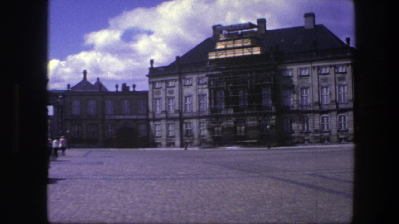 Palace courtyard with scaffolding and a few distant pedestrians near the buildings.