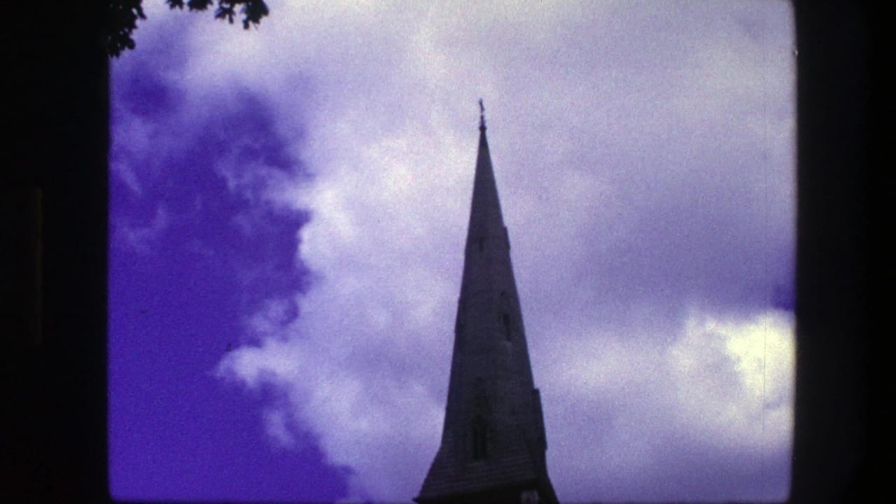 Cone-shaped church spire rising into a purple-blue cloudy sky.