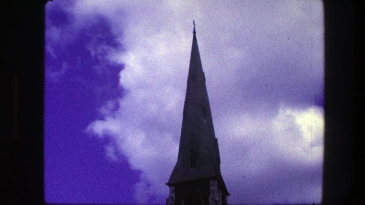Church spire near the right side of a cloud-filled purple sky.