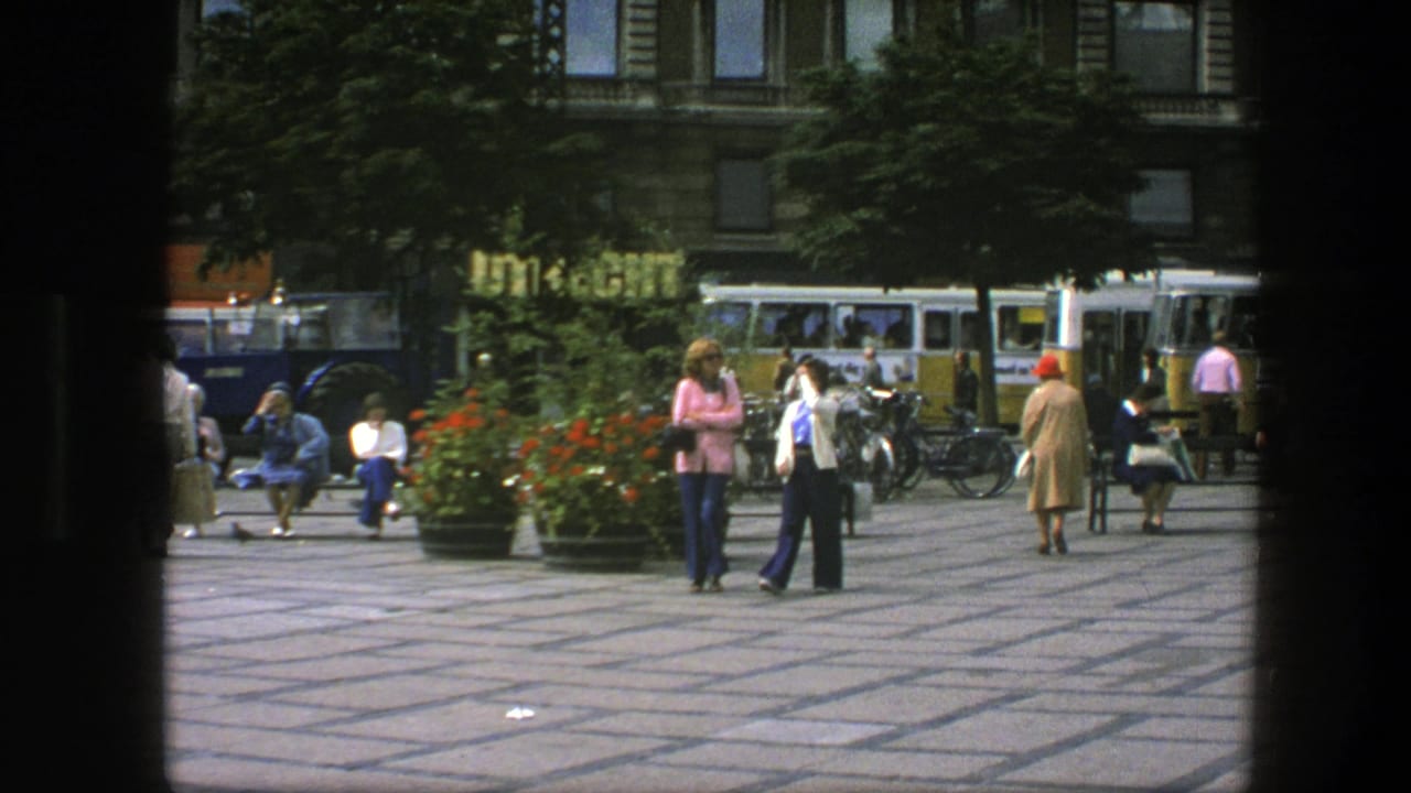A 1975 Copenhagen plaza view shows pedestrians moving past benches and planters with bicycles and vintage buses in the background.