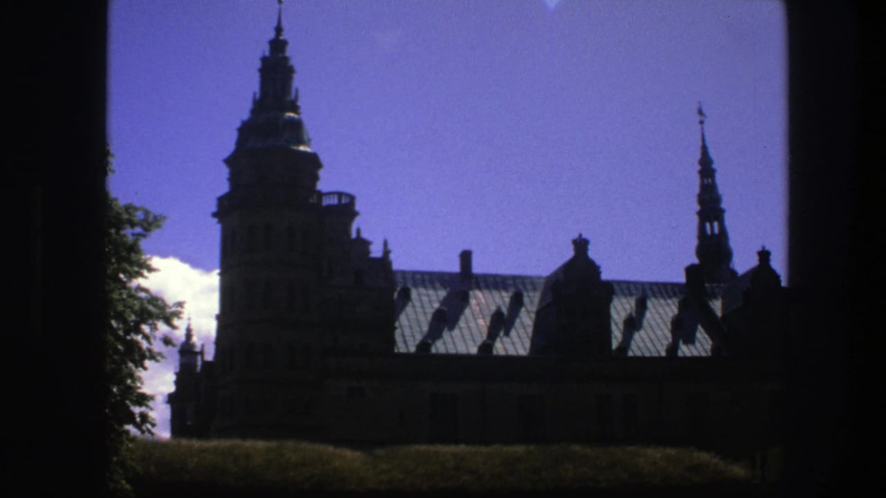 Silhouetted church roofline and steeples against a blue sky, framed by dark foreground edges.