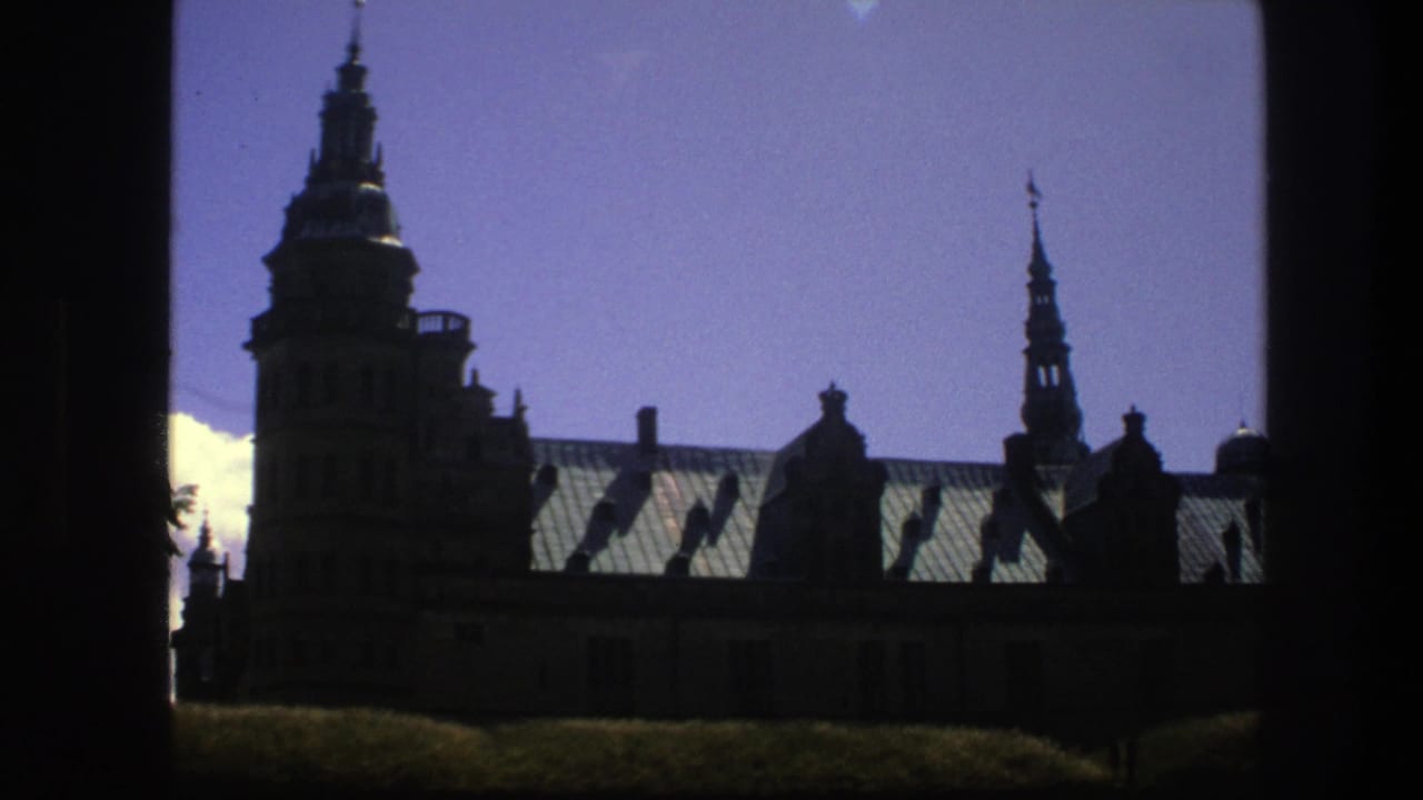 Copenhagen church spires and roof details appear in a dark, high-contrast 8mm travel frame from 1975.