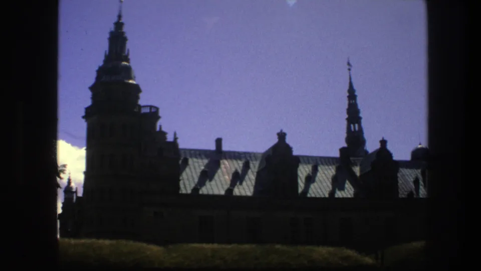 Copenhagen church spires and roof details appear in a dark, high-contrast 8mm travel frame from 1975.