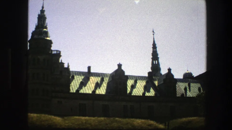 1975 Copenhagen 8mm view of a historic church roof and spire, softened by glare and film grain.
