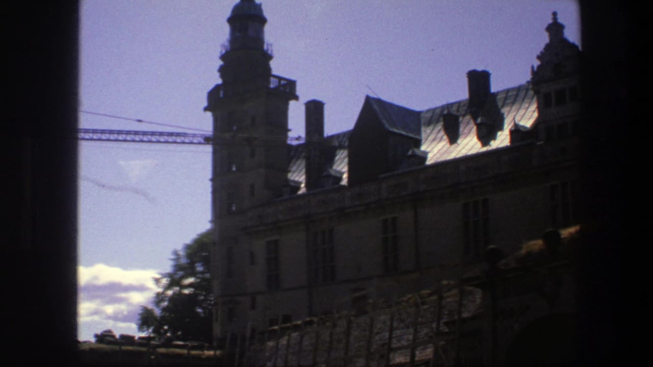 1975 Copenhagen frame with the castle tower, chimneys, roof sections, dark foreground edge, and a construction crane behind the building.