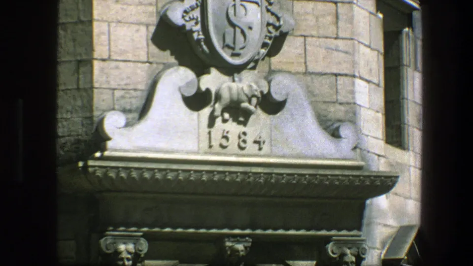 Copenhagen architectural detail in 1975 home-movie footage, centered on a carved stone ornament above a doorway.