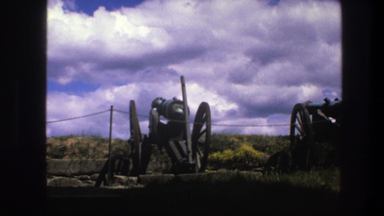 Old cannon centered on a grassy rise with another cannon partly visible at right.