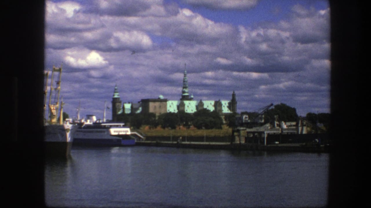 Copenhagen harbor with white boats, palace roofs, spires, water, and heavy clouds.