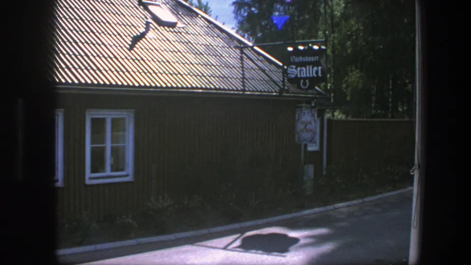 A later frame shows a wooden roadside building with windows, a tiled roof, and a hanging sign reading Stallet.