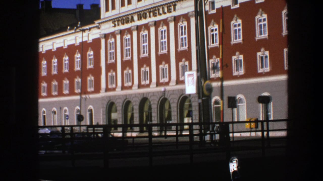 Closer view of the hotel facade with arched windows and street signs.