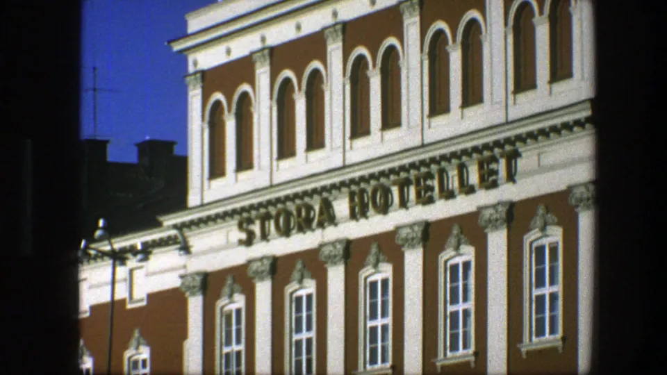 1975 Copenhagen close exterior of the STORA HOTELLET facade, showing the sign, decorative trim, arched windows, and blue sky.