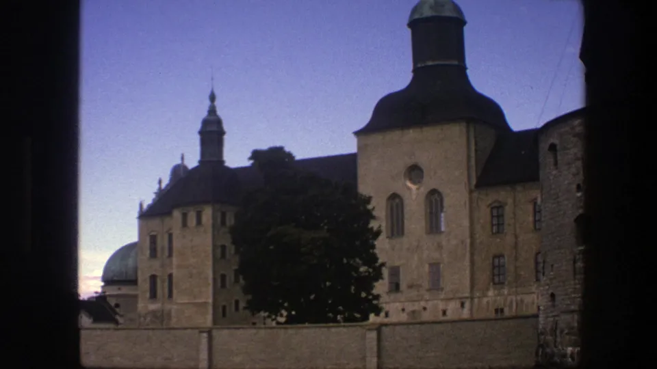 Copenhagen 1975 travel footage shows green domes, tan masonry, tower roofs, a tree, and a low wall under clear sky.